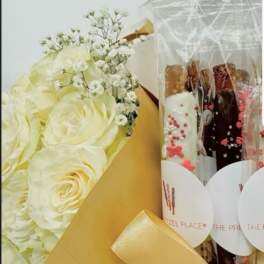 White rose bouquet beside wrapped chocolate bars in clear plastic