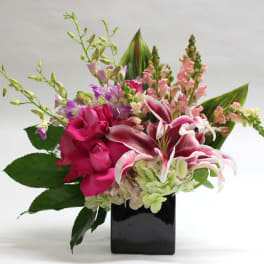 Pink lilies and roses in a black square vase