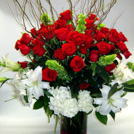 Red roses and white lilies arranged in a glass vase