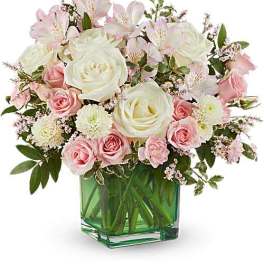 Pink and white roses with alstroemeria in a green glass vase