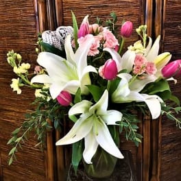 Bouquet of white lilies and pink tulips in a glass vase