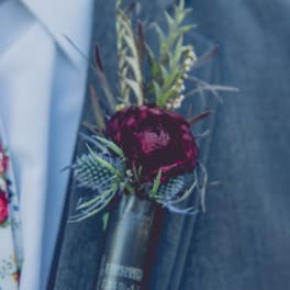 Dark red boutonniere pinned to a suit jacket