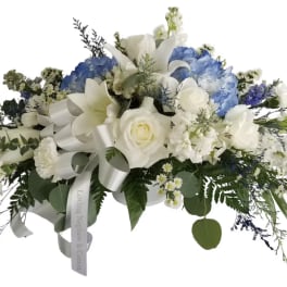 White and blue floral spray with a ribbon bow