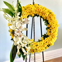 Yellow rose wreath with white orchids on a standing easel