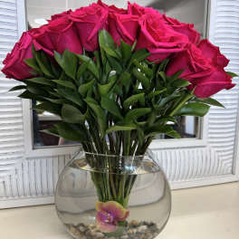 Bouquet of hot pink roses in a round glass vase