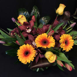 Bouquet of yellow roses, orange gerbera daisies, and burgundy orchids