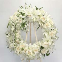 White floral wreath on a wooden stand