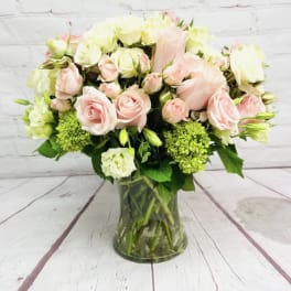 Pink and white roses arranged in a glass vase