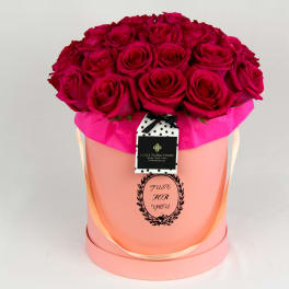 Bouquet of deep pink roses in a pink hatbox