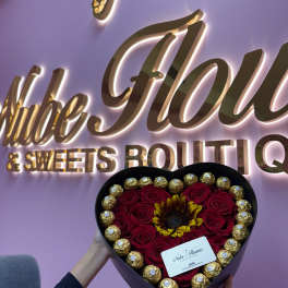 Heart-shaped box of red roses with a sunflower and gold chocolates