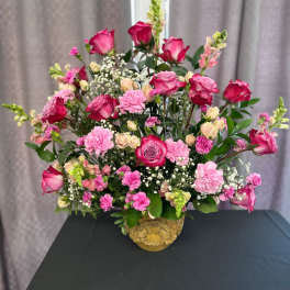 Pink roses and carnations arranged in a gold vase