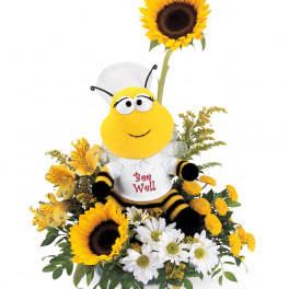 Bee plush in a flower arrangement with sunflowers and white daisies