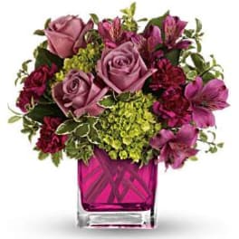 Pink and purple mixed bouquet in a magenta glass vase
