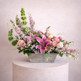 Pink lilies and roses in a gray rectangular planter