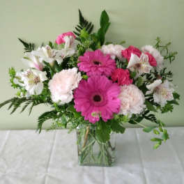 Pink gerberas and white alstroemeria in a clear glass vase