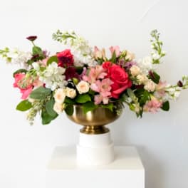 Mixed pink and white flower arrangement in a gold bowl vase
