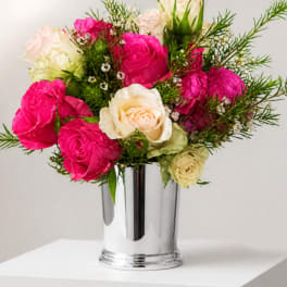 Pink and cream roses arranged in a silver vase