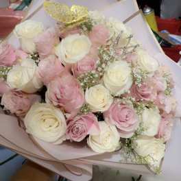 Bouquet of pink and white roses with decorative crown picks