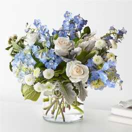 Blue and white flower arrangement in a clear glass vase