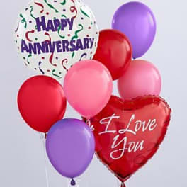 Cluster of anniversary balloons in red, pink, purple, and white