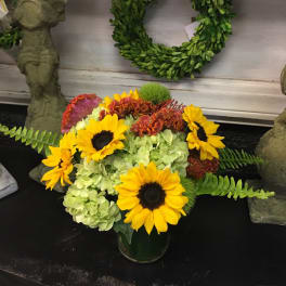 Bouquet of sunflowers and green hydrangeas in a glass vase