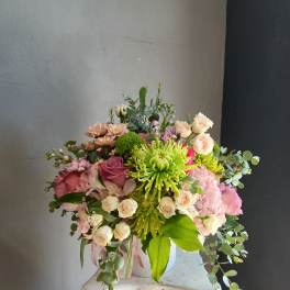 Mixed bouquet with pink and cream flowers in a white vase