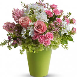 Pink and white mixed flower arrangement in a green vase