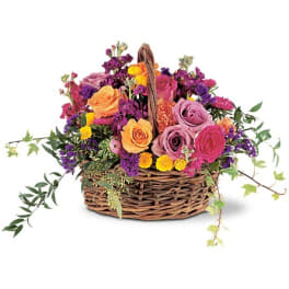 Mixed roses and purple flowers in a wicker basket