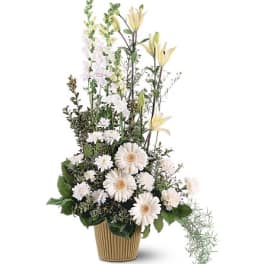 Tall white floral arrangement in a ribbed pot with daisy-like blooms