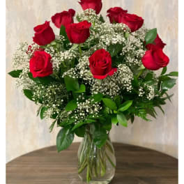 Red roses with baby's breath in a clear glass vase