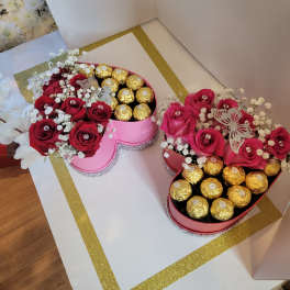 Heart-shaped boxes with red roses and gold-wrapped chocolates