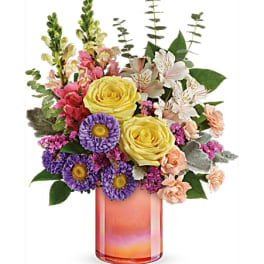 Mixed bouquet in a pink glass vase with yellow roses and purple daisies