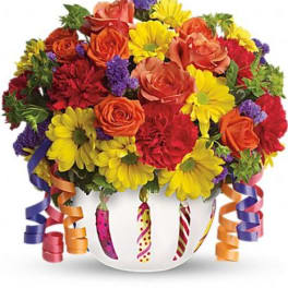 Mixed bouquet of roses and daisies in a white vase with curling ribbons