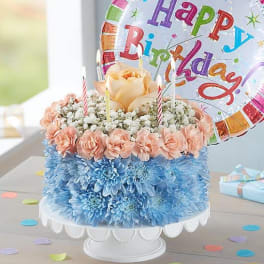 Birthday cake decorated with flowers and a balloon topper
