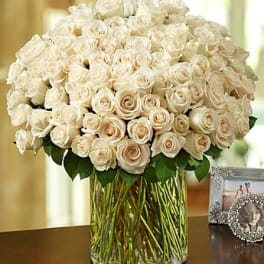 Large bouquet of cream roses in a clear glass vase