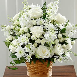 White roses and daisies arranged in a woven basket