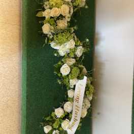 White rose floral arrangement with a ribbon reading Loving Husband