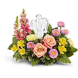 Mixed flower arrangement with a white angel figurine