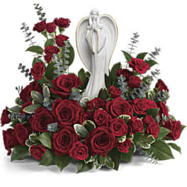 Red rose arrangement with a white angel statue centerpiece