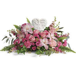 Pink lilies and roses arranged around a memorial angel heart plaque
