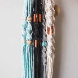 Macrame wall hangings in pastel blue, black, gray, and cream