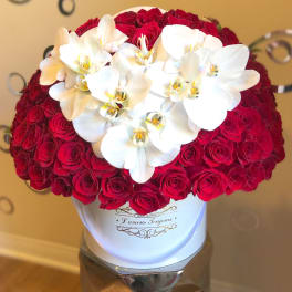 Red roses with white orchids in a white hat box