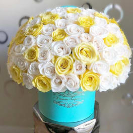 Bouquet of white and yellow roses in a turquoise hat box