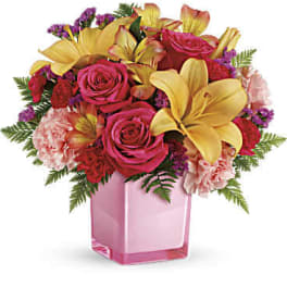 Pink roses and yellow lilies in a pink glass vase