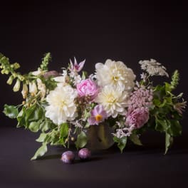 Low floral arrangement with white and pink blooms in a vase