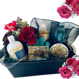 Gift basket with roses and bath products in a dark container