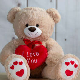 Plush teddy bear holding a red heart with "I Love You" text