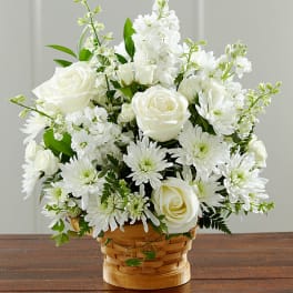 White roses and daisies arranged in a woven basket