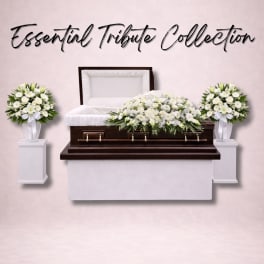 White funeral casket with matching white floral sprays on pedestals