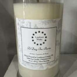Large cream-colored candle in a glass jar with a metal lid